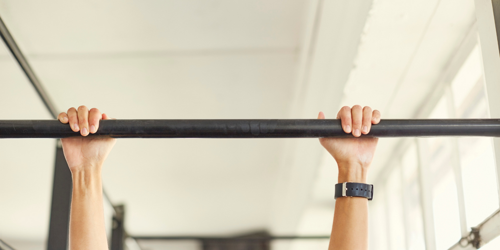 Two hands grabbing an indoor pull up bar