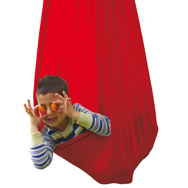 A child is playing in the red sensory swing