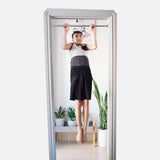 A teen boy is doing pull-ups on a doorway pull-up bar