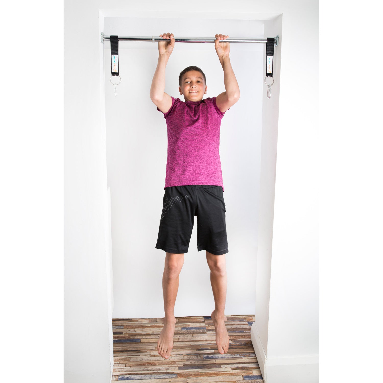 A teen boy is doing pull-ups on DreamGYM support bar.