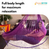 A woman is resting in a hammock swing. It provides full body length for maximum relaxation. Beautiful violet colour.