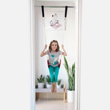 a girl is using a classic swing installed in a door frame