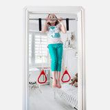 A girl is doing pull-ups on a doorway swing support bar.