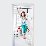 DreamGM Doorway Swing. A girl is using a doorway trapeze bar and gymnastics rings