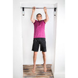 A teen boy is doing pull-ups on DreamGYM support bar. 