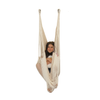 A girl is sitting in a Therapy Hammock Swing with her plush toy- Soft Ivory - DreamGYM