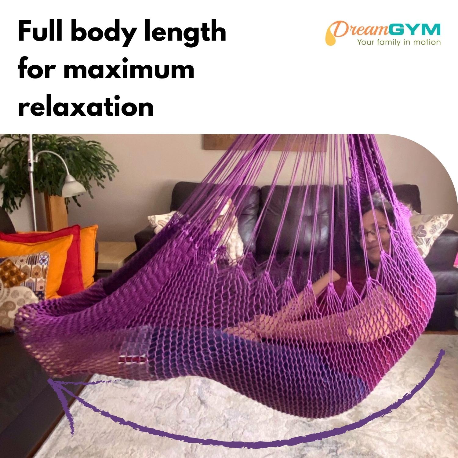 A woman is resting in a hammock swing. It provides full body length for maximum relaxation. Beautiful violet colour.