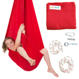 DreamGYM Sensory Swing from Canada. A happy girl is sitting inside a red sensory swing. Components included in the kit are a sensory swing, two pieces of rope, eye hook, lag shield and a snap link. 